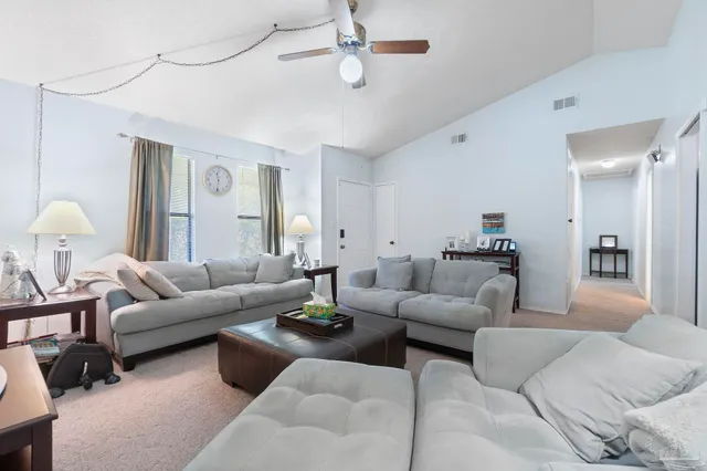 a living room with furniture ceiling fan and a rug