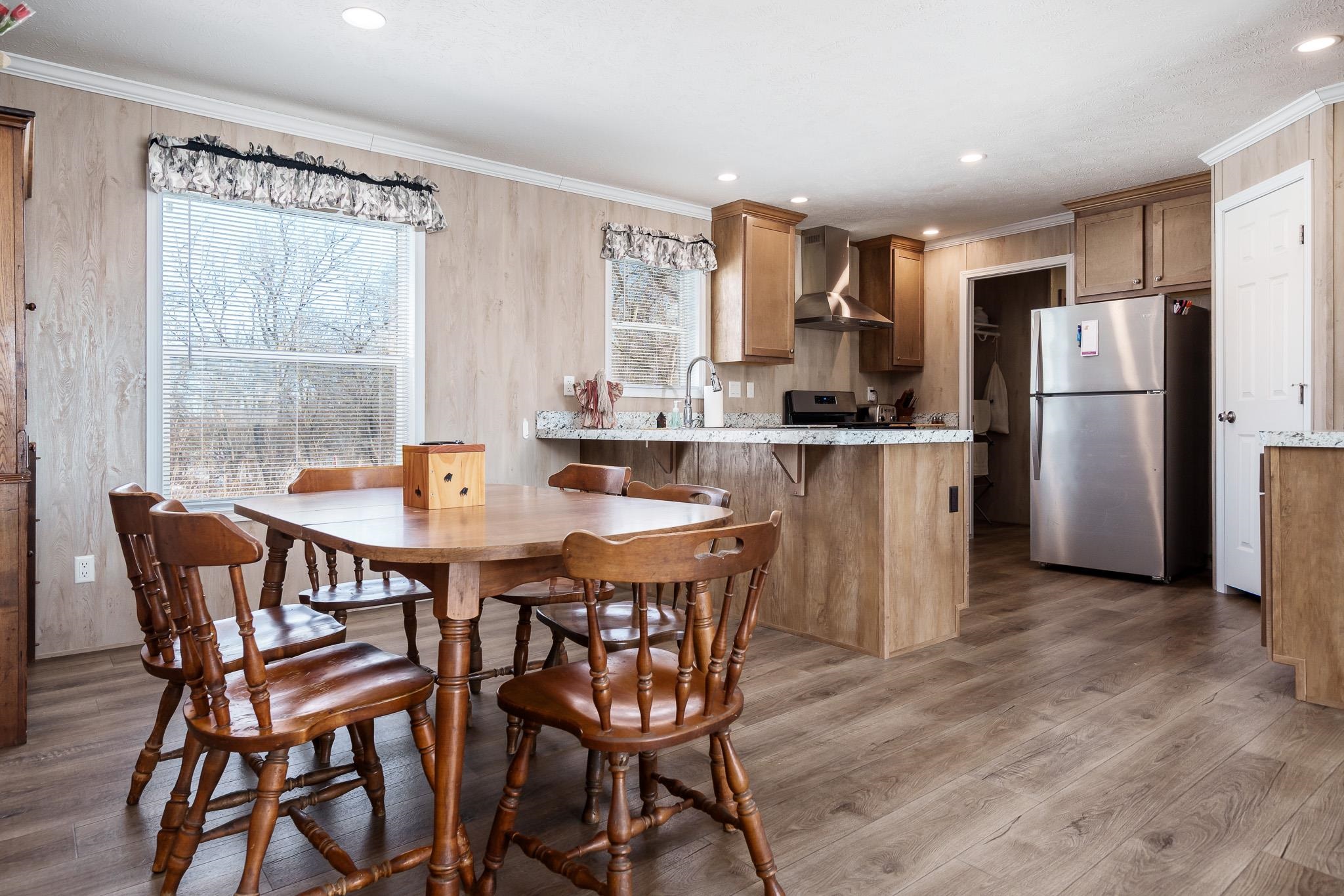 11447 South County Rd K Beloit, WI 53511 - Photo 19 of 51 a kitchen with a table chairs refrigerator and cabinets