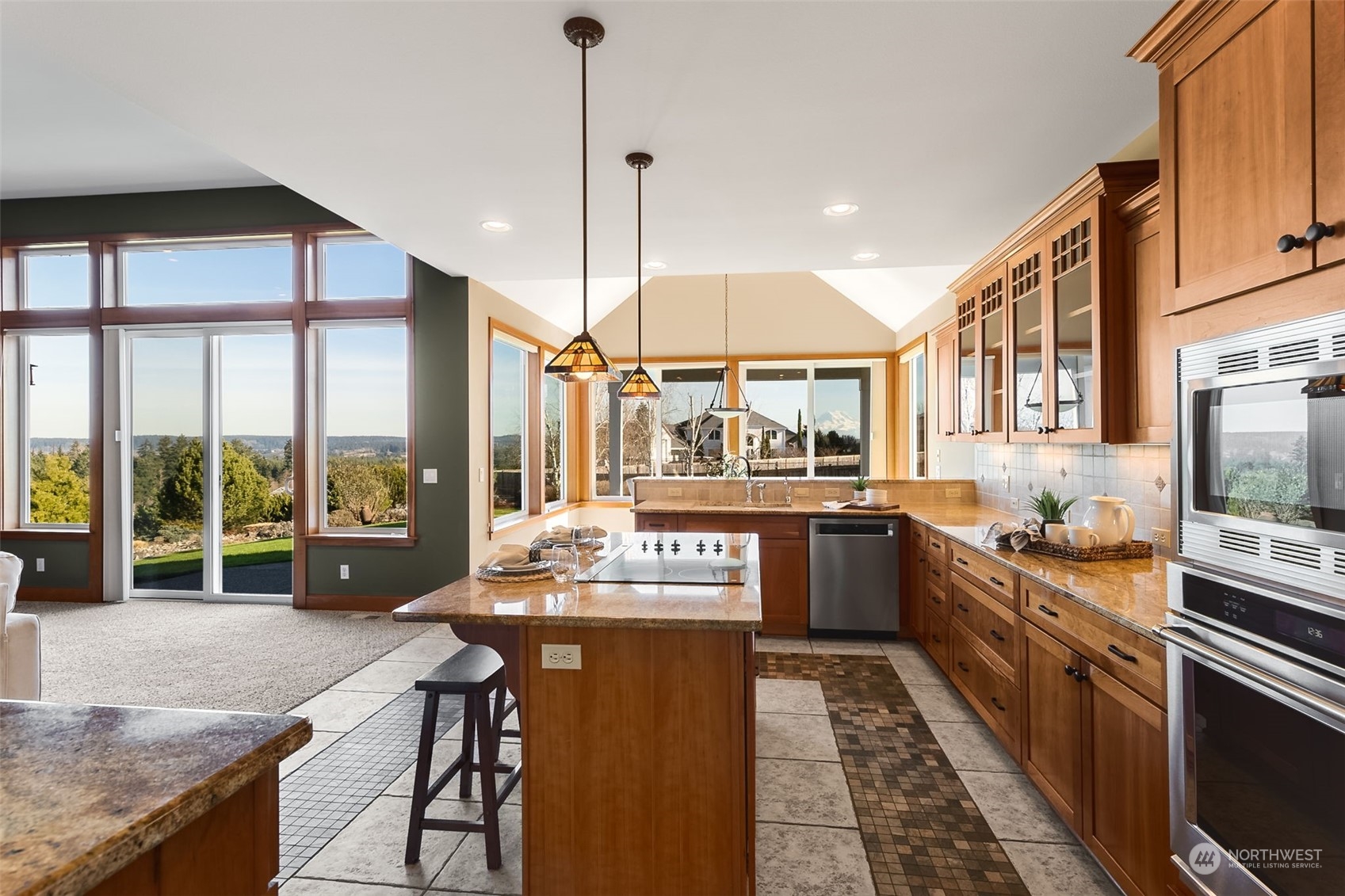 9306 Milburn Loop Southeast Olympia, WA 98513 - Photo 9 of 40 a kitchen with stainless steel appliances granite countertop a stove a sink and a dining table with wooden floor