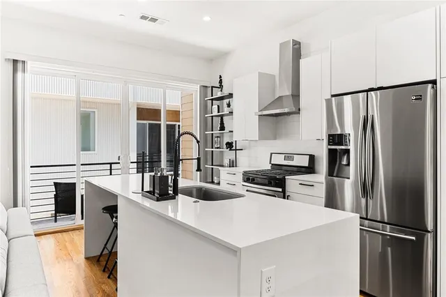 a kitchen with stainless steel appliances a refrigerator sink and stove