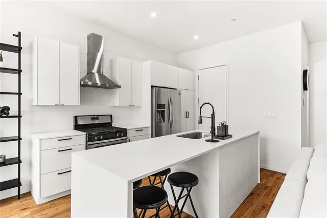 a kitchen with stainless steel appliances a stove a sink and a refrigerator