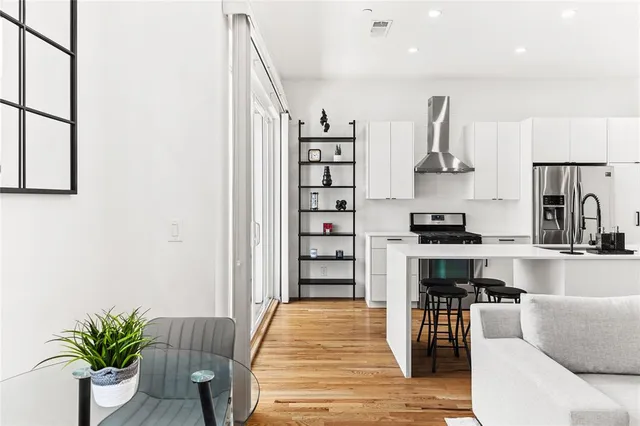 a kitchen with stainless steel appliances kitchen island granite countertop a refrigerator and a sink