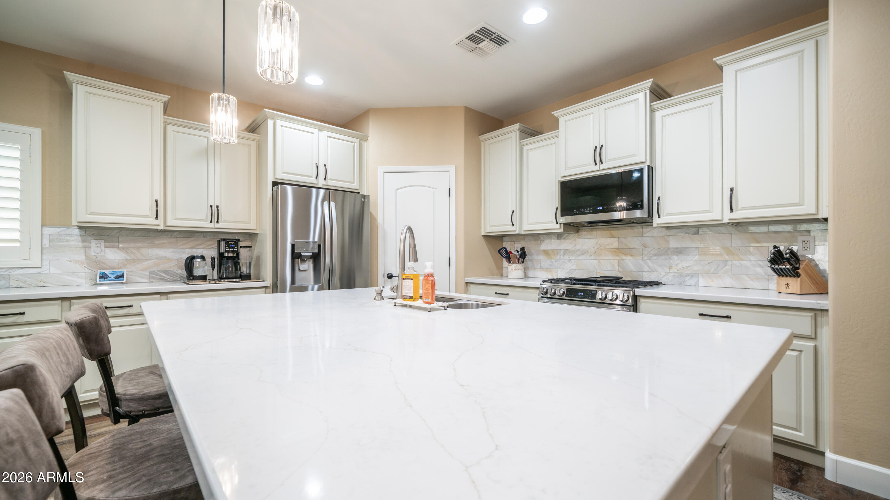 10754 West Yearling Road Peoria, AZ 85383 - Photo 10 of 35 a kitchen with stainless steel appliances a stove a sink a refrigerator a microwave and cabinets