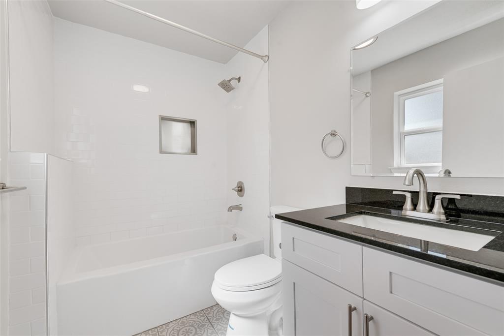 4010 Burning Tree Lane Garland, TX 75042 - Photo 14 of 20 a bathroom with a granite countertop sink a toilet and a bathtub
