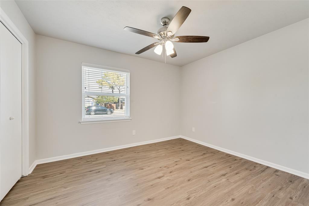 4010 Burning Tree Lane Garland, TX 75042 - Photo 15 of 20 an empty room with wooden floor chandelier fan and windows