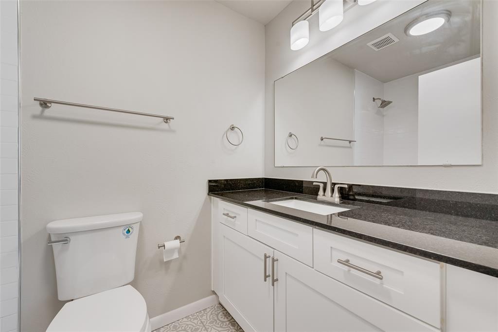 4010 Burning Tree Lane Garland, TX 75042 - Photo 16 of 20 a bathroom with a granite countertop sink a toilet and a mirror
