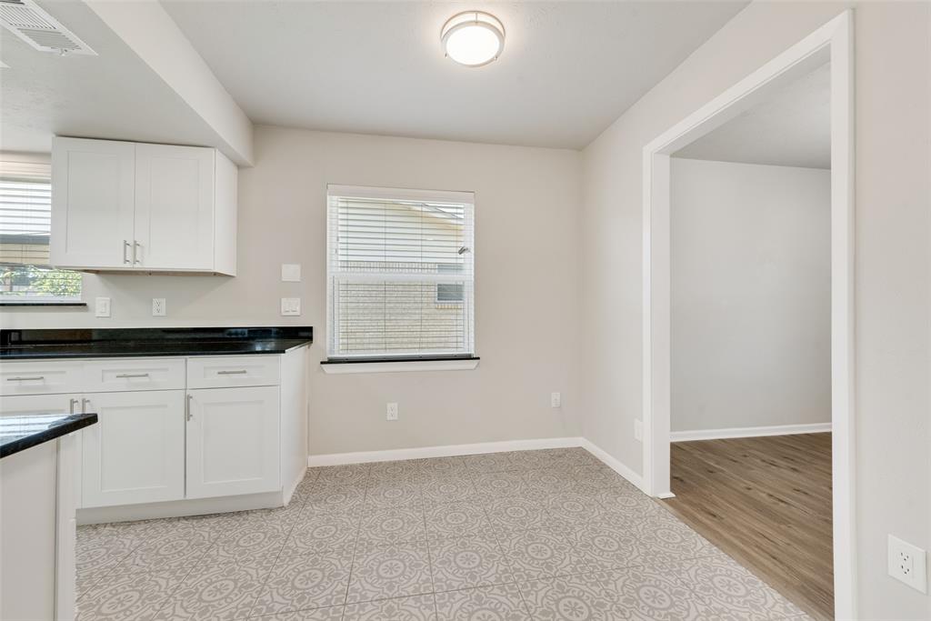 4010 Burning Tree Lane Garland, TX 75042 - Photo 8 of 20 a kitchen with granite countertop white cabinets and window