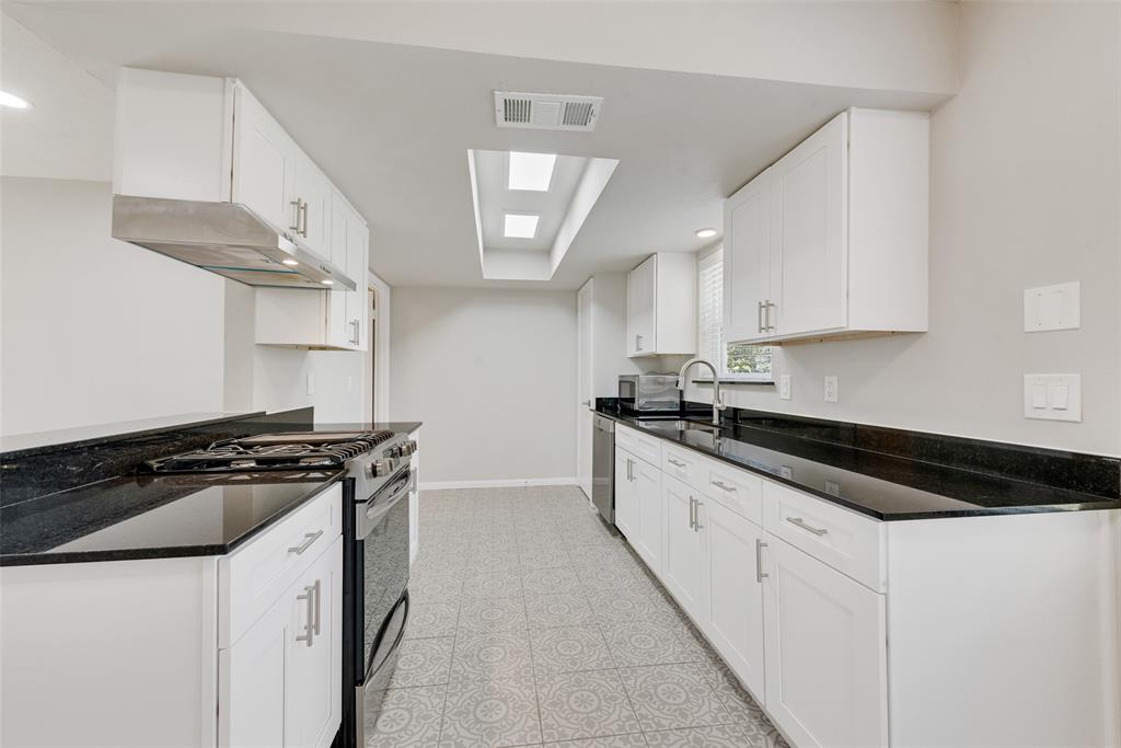 4010 Burning Tree Lane Garland, TX 75042 - Photo 9 of 20 a kitchen with stainless steel appliances granite countertop a stove a sink and a microwave