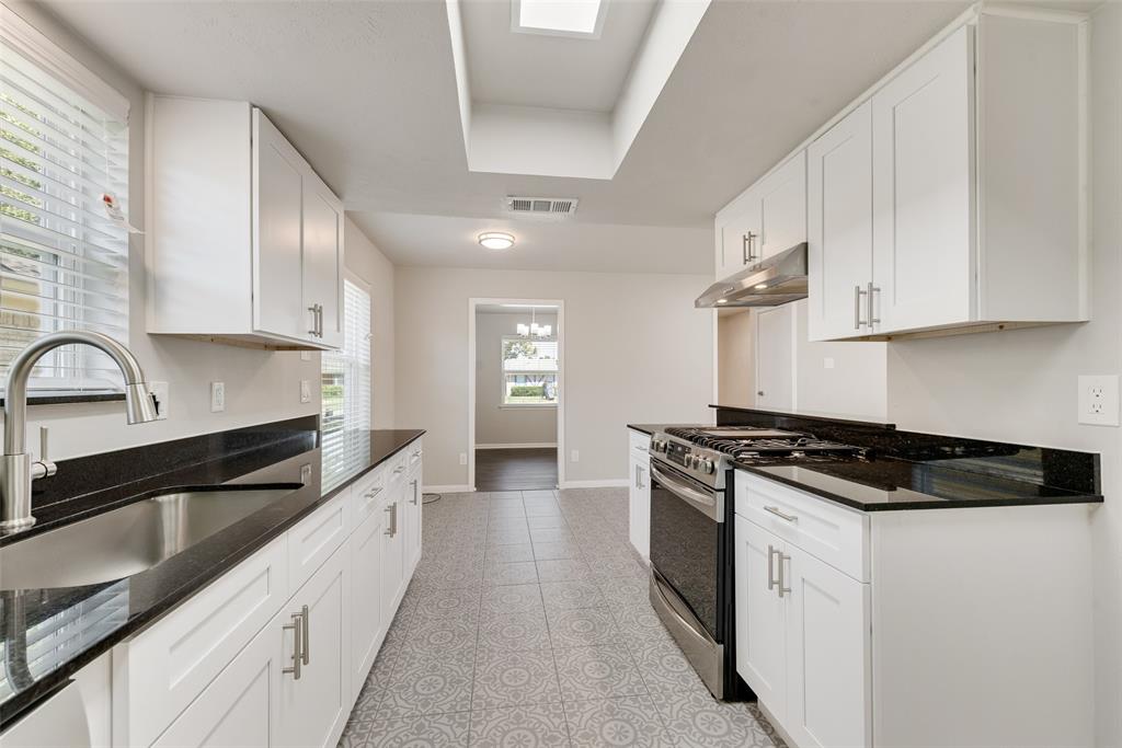 4010 Burning Tree Lane Garland, TX 75042 - Photo 10 of 20 a kitchen with granite countertop white cabinets and stainless steel appliances