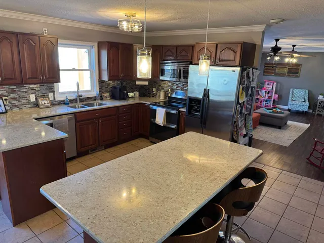 a kitchen with stainless steel appliances granite countertop a sink a stove and a refrigerator