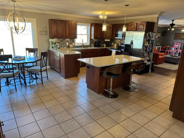 a kitchen with a stove a sink dishwasher and a refrigerator with wooden cabinets