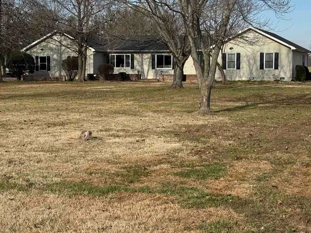 a view of a house with yard and chairs