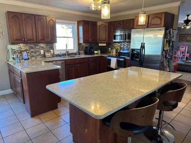 a kitchen with stainless steel appliances granite countertop a refrigerator a sink and dishwasher
