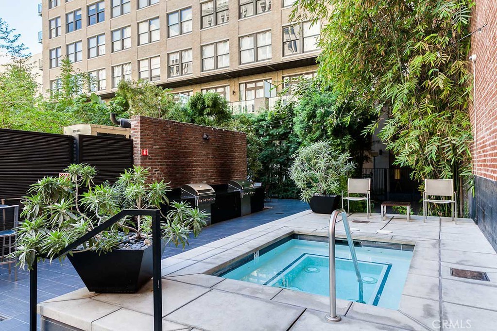 460 South Spring Street, Unit 1013 Los Angeles, CA 90013 - Photo 14 of 25 a view of a patio with table and chairs potted plants and large tree