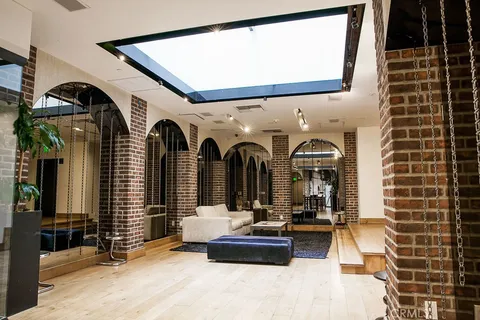 a view of a pathway with plants and large trees