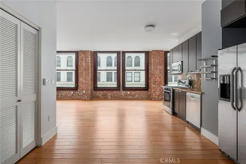a large kitchen with a large window a refrigerator and a sink