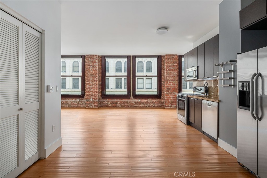 460 South Spring Street, Unit 1013 Los Angeles, CA 90013 - Photo 2 of 25 a large kitchen with a large window a refrigerator and a sink