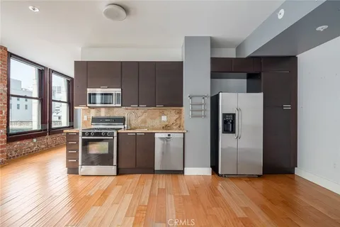 a kitchen with stainless steel appliances granite countertop a refrigerator stove and sink