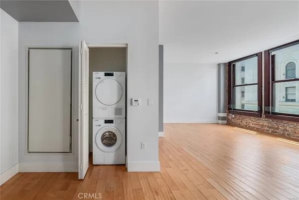 an empty room with wooden floor and mirror