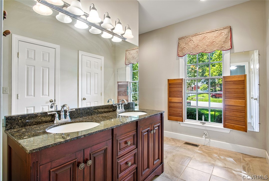4019 Belspring Road Chester, VA 23831 - Photo 22 of 46 a bathroom with a granite countertop sink a large mirror and a window