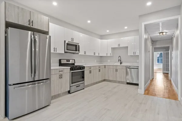 a kitchen with white cabinets and stainless steel appliances