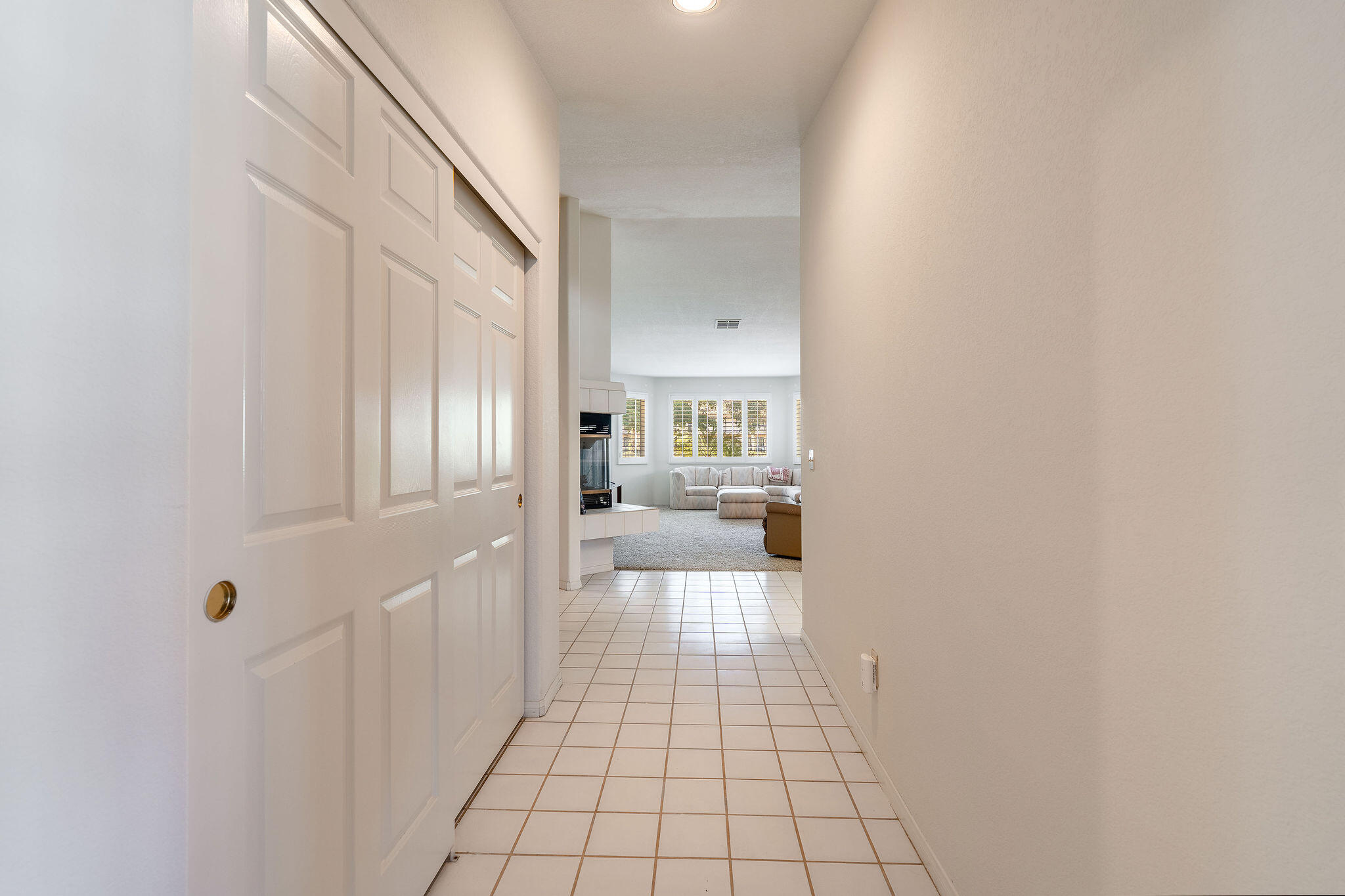 82151 Hanson Drive Indio, CA 92201 - Photo 10 of 38 a hallway with a view of living room with a mirror