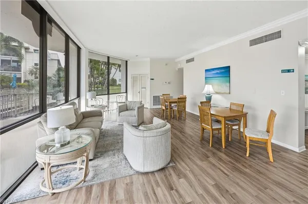 a living room with furniture a wooden floor and a large window