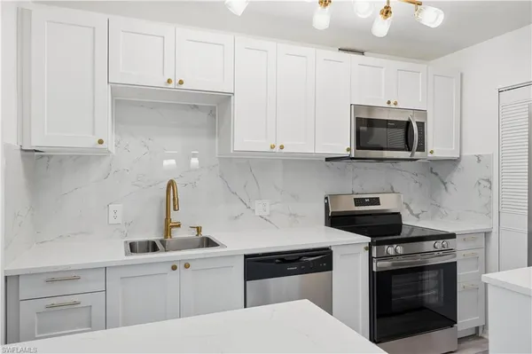 a kitchen with cabinets stainless steel appliances and a counter space