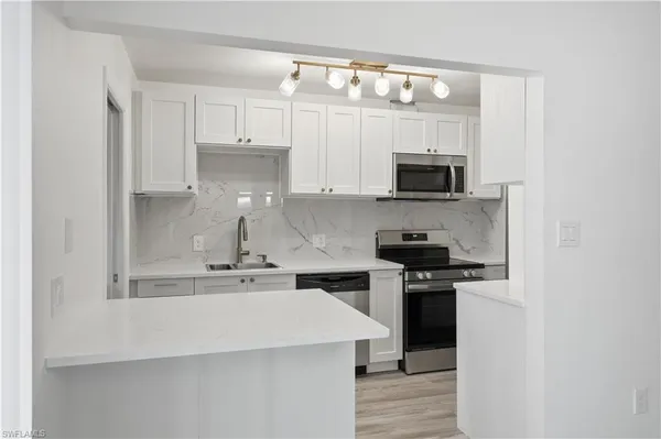 a kitchen with stainless steel appliances a stove microwave and sink