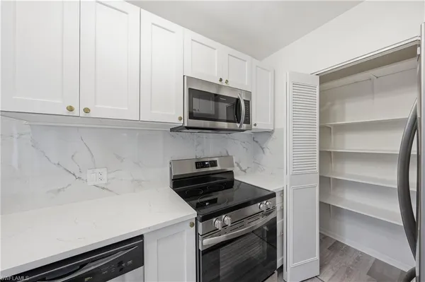 a kitchen with granite countertop a stove and a microwave
