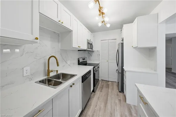 a kitchen with a sink a refrigerator and cabinets