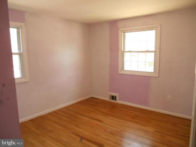 12718 Bushey Drive Silver Spring, MD 20906 - Photo 8 of 19 an empty room with wooden floor and windows