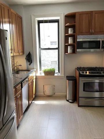 a kitchen with stainless steel appliances granite countertop a stove and a refrigerator