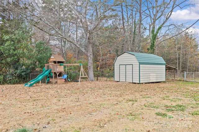 a view of a house with a yard and large tree