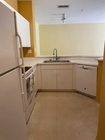 a kitchen with white cabinets and white appliances