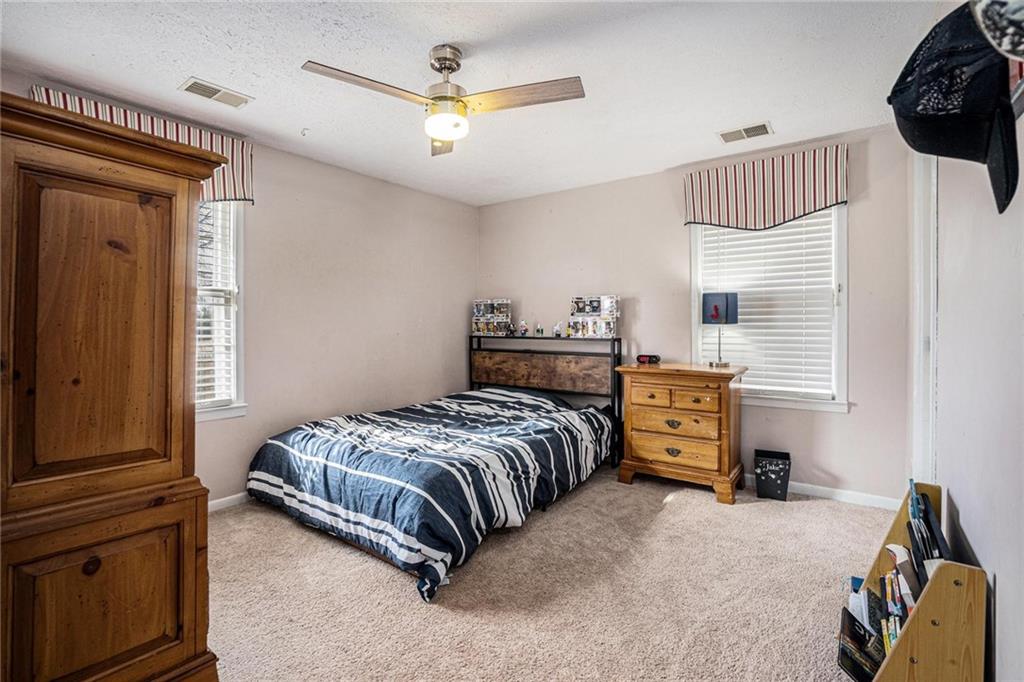 4034 Beaver Road Southwest Loganville, GA 30052 - Photo 16 of 24 a bedroom with a bed and a chandelier