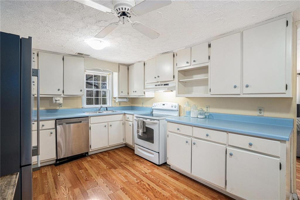 4034 Beaver Road Southwest Loganville, GA 30052 - Photo 6 of 24 a kitchen with granite countertop white cabinets and white appliances