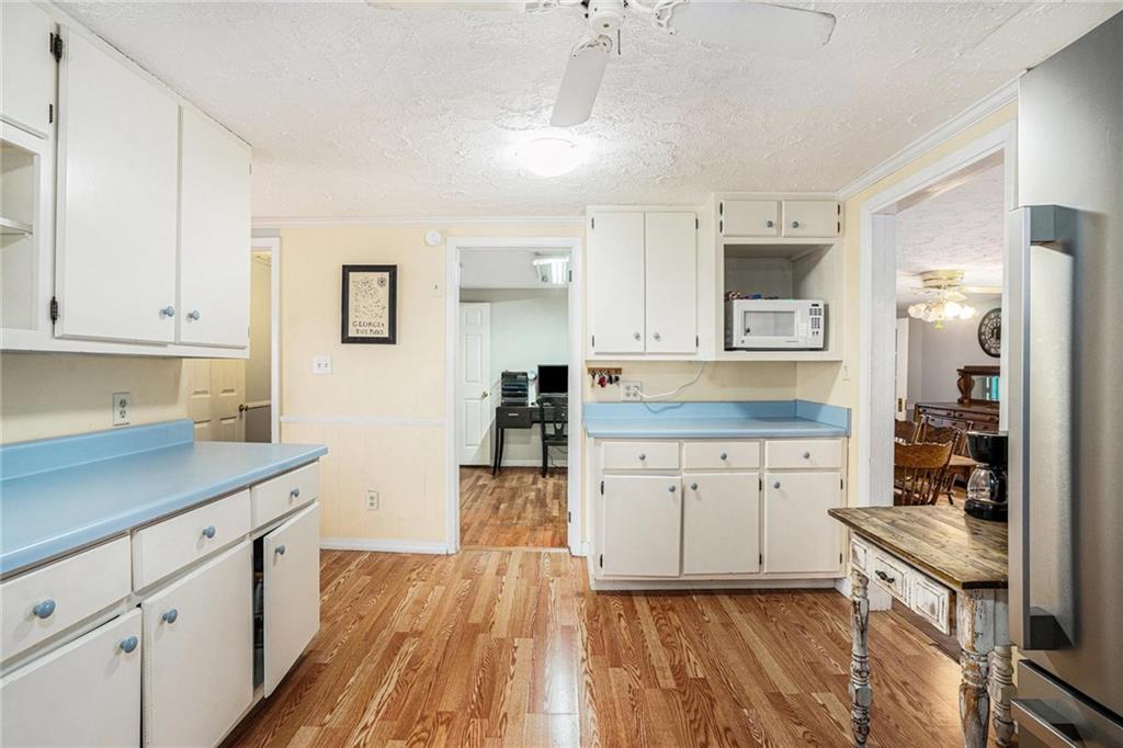 4034 Beaver Road Southwest Loganville, GA 30052 - Photo 8 of 24 a kitchen with granite countertop white cabinets and white appliances