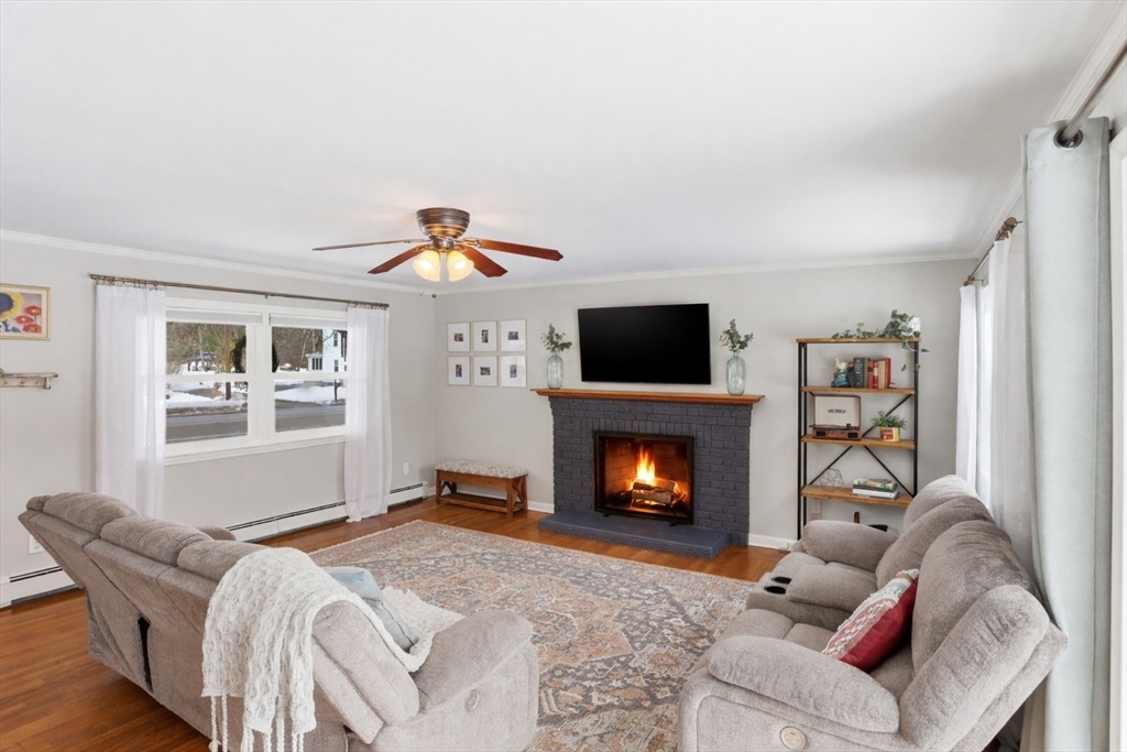 37 Sterling Street Lancaster, MA 01523 - Photo 7 of 33 a living room with furniture a flat screen tv and a fireplace