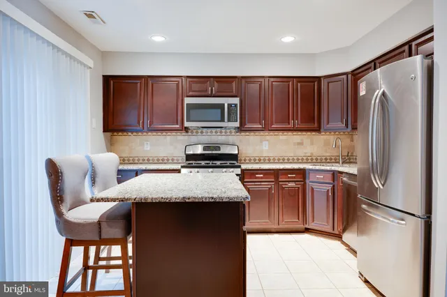 a kitchen with stainless steel appliances granite countertop a refrigerator stove microwave and sink