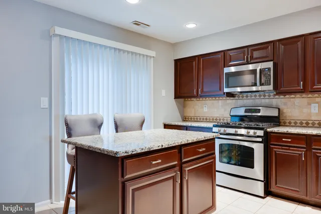 a kitchen with granite countertop cabinets stainless steel appliances and a sink