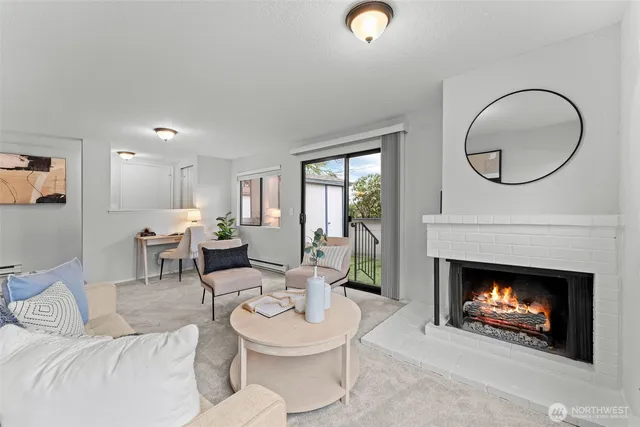 a living room with furniture a fireplace and a large window