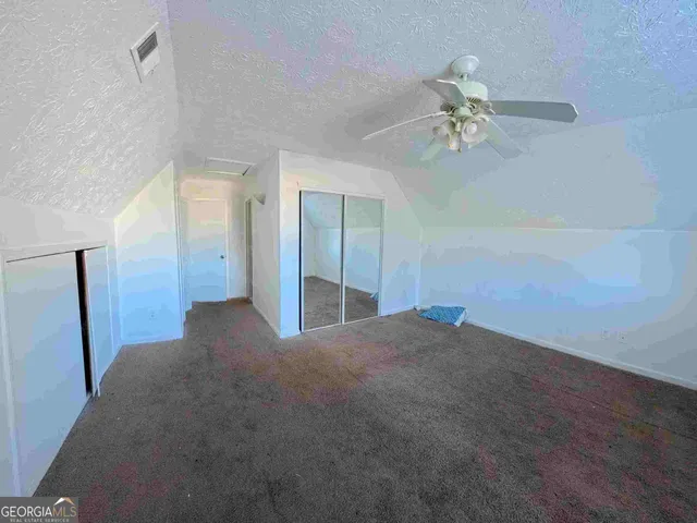 a view of a big room with chandelier fan and windows