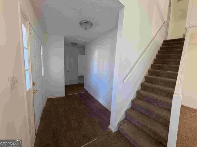 a view of staircase with lots of frames on wall and a window