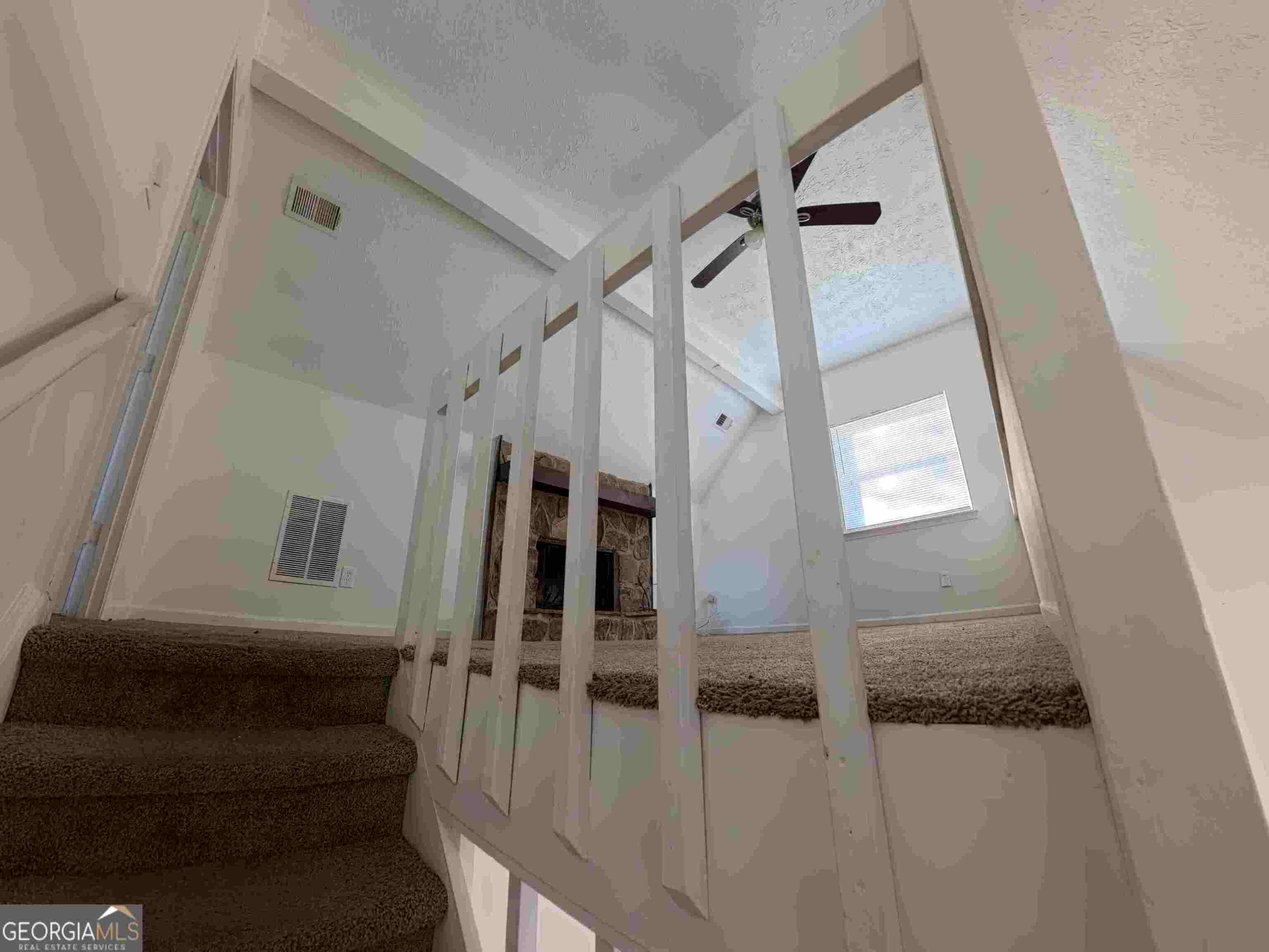 11187 Shannon Circle Hampton, GA 30228 - Photo 20 of 22 a view of staircase with lots of frames on wall and a window