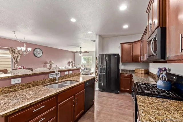 a kitchen with stainless steel appliances granite countertop a refrigerator and a sink