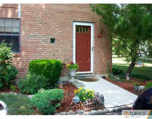 a view of a brick house with a yard and plants