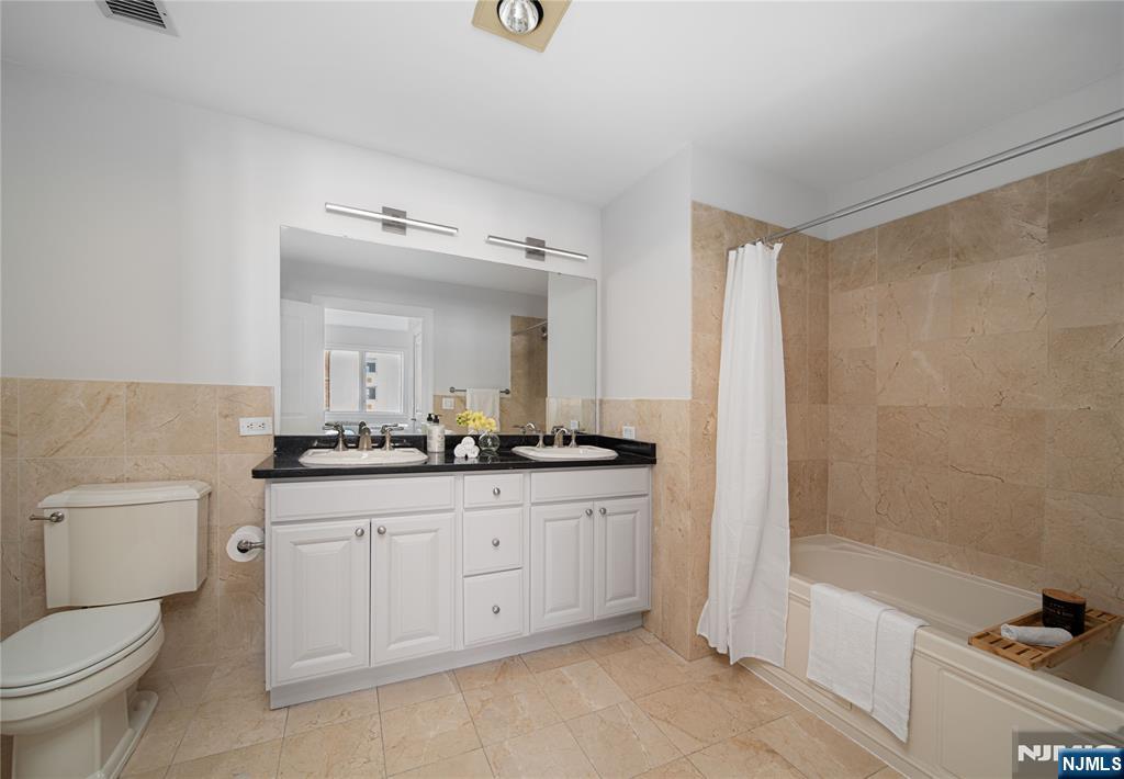 6404 City Place Edgewater, NJ 07020 - Photo 13 of 22 a bathroom with a granite countertop sink a toilet and a bathtub