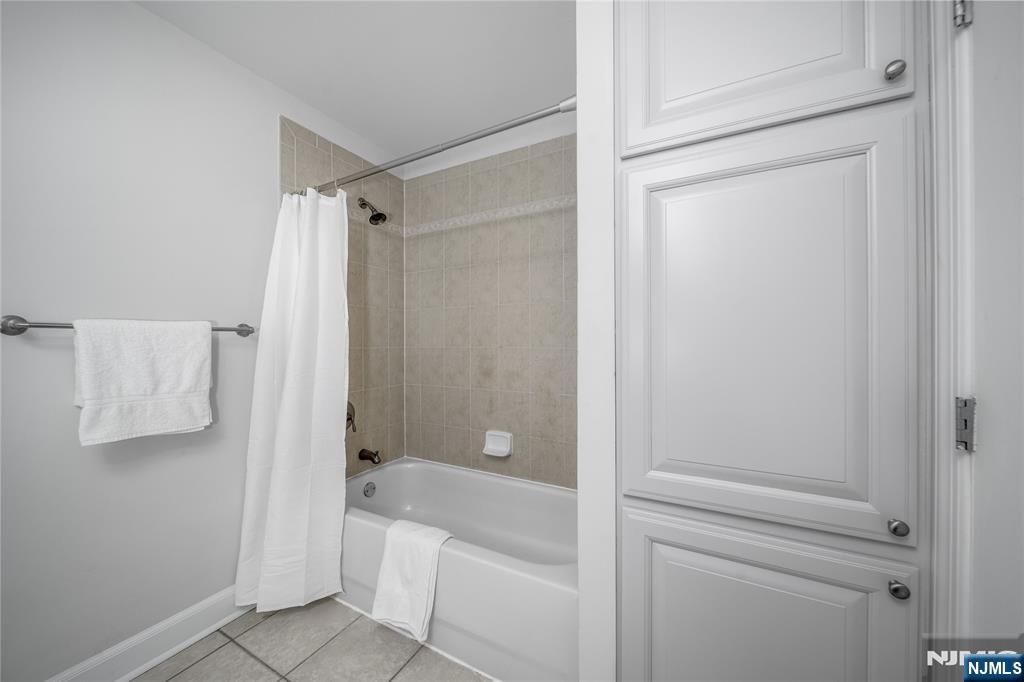 6404 City Place Edgewater, NJ 07020 - Photo 18 of 22 a bathroom with a shower and a tub