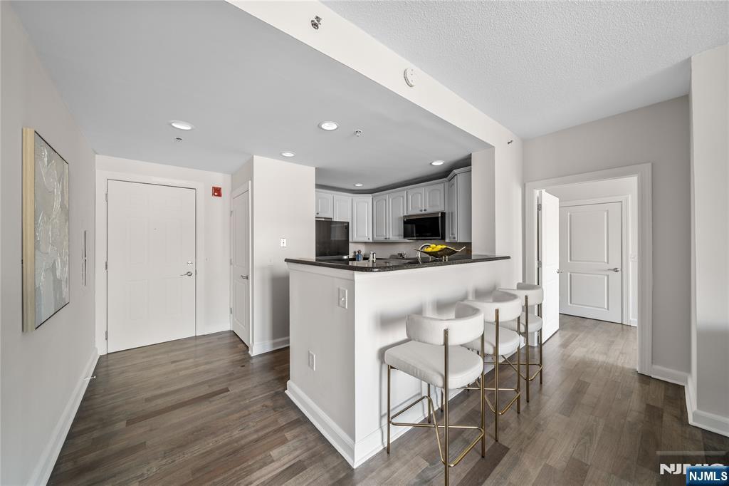6404 City Place Edgewater, NJ 07020 - Photo 6 of 22 a kitchen with stainless steel appliances kitchen island granite countertop a refrigerator and microwave
